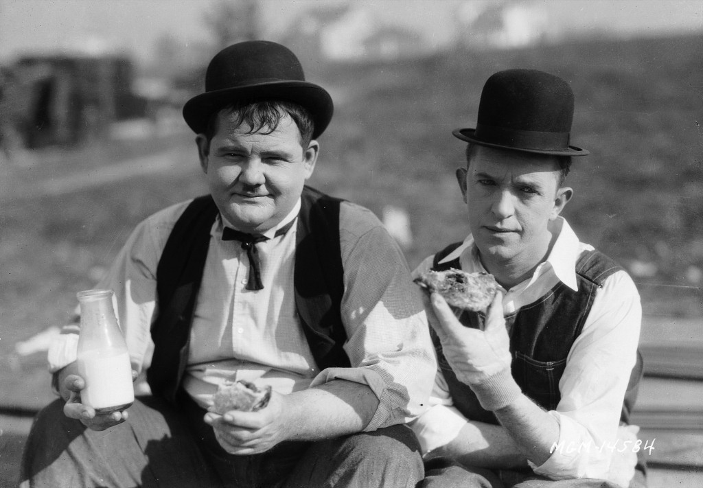 Stan Laurel and Oliver Hardy stop for milk and sandwiches, during a break from filming the silent sh